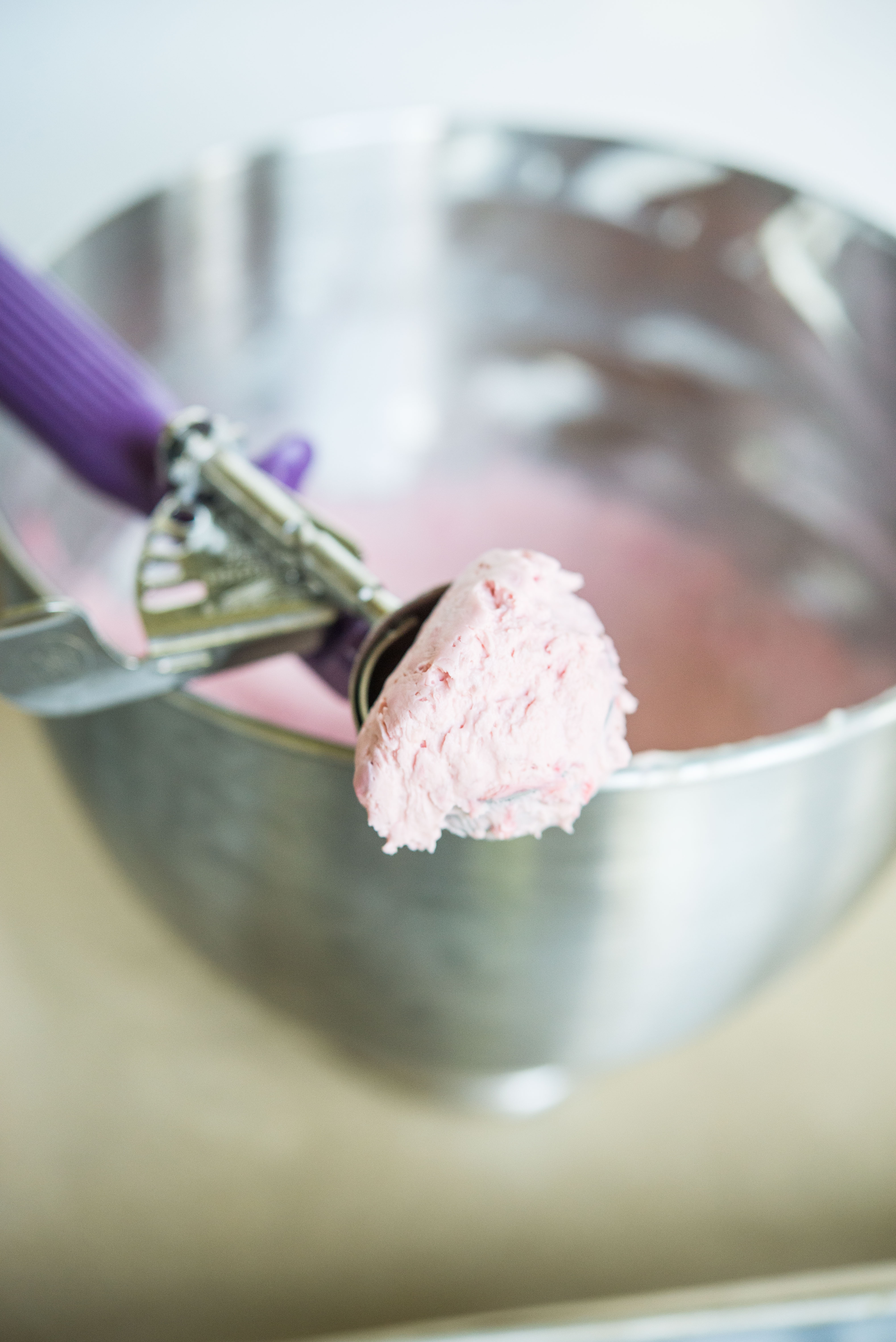 an ice cream scoop filled with raspberry cream cheese mixture