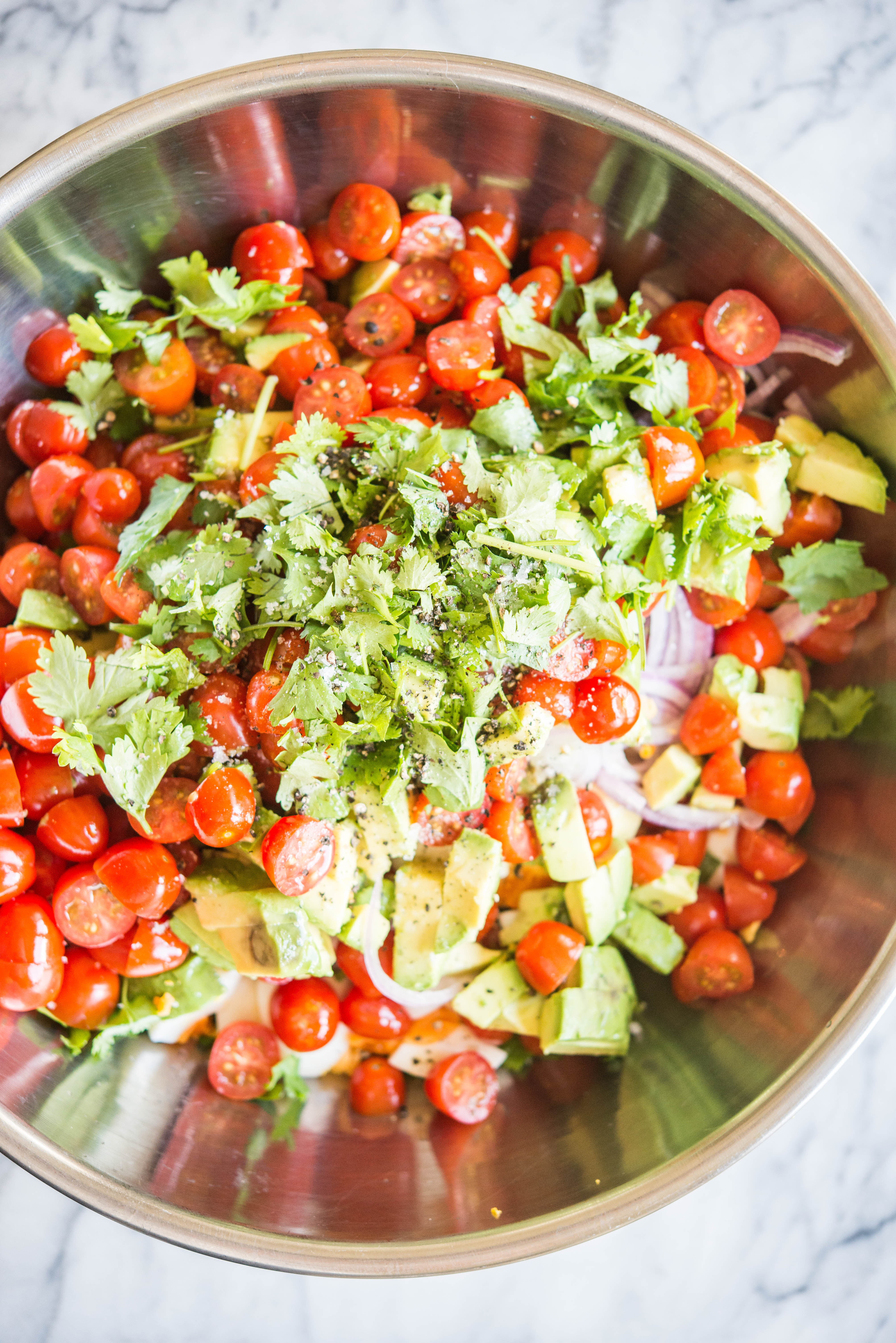 breakfast salad ingredients in a metal bowl on a marble board