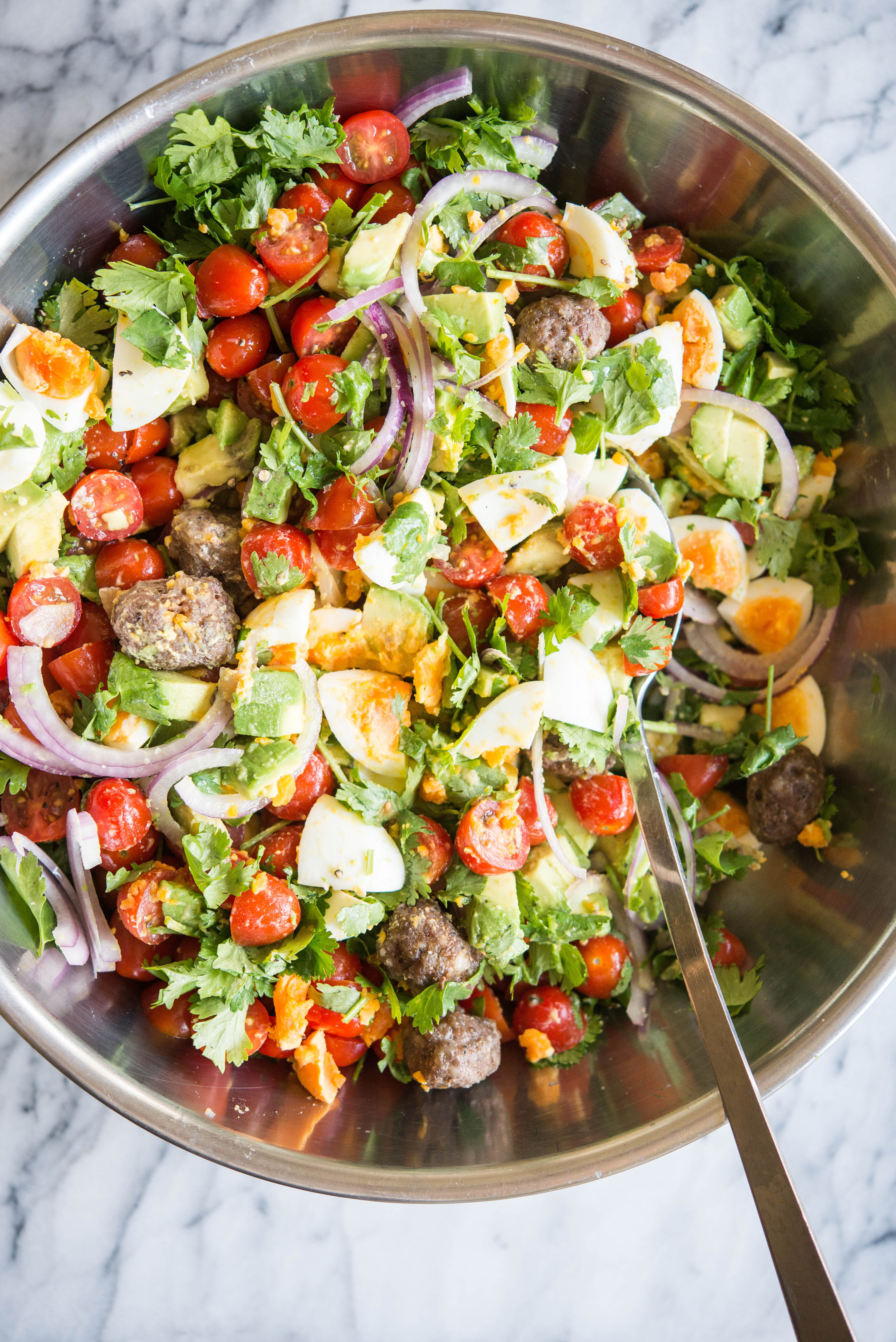 Breakfast salad in a metal bowl on a marble board