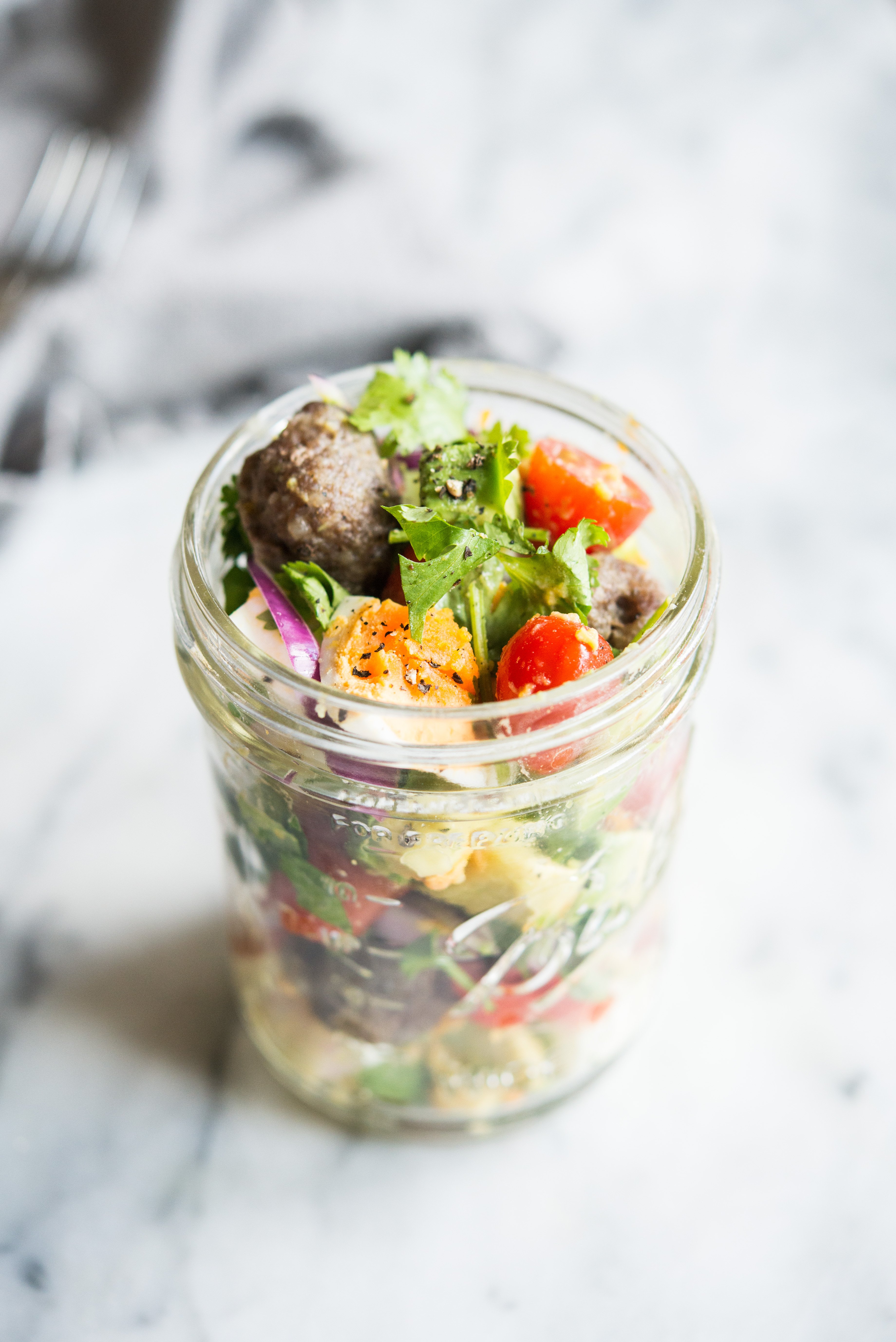 breakfast salad in a mason jar on a marble board