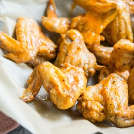 crispy baked buffalo chicken wings in a bowl lined with parchment paper