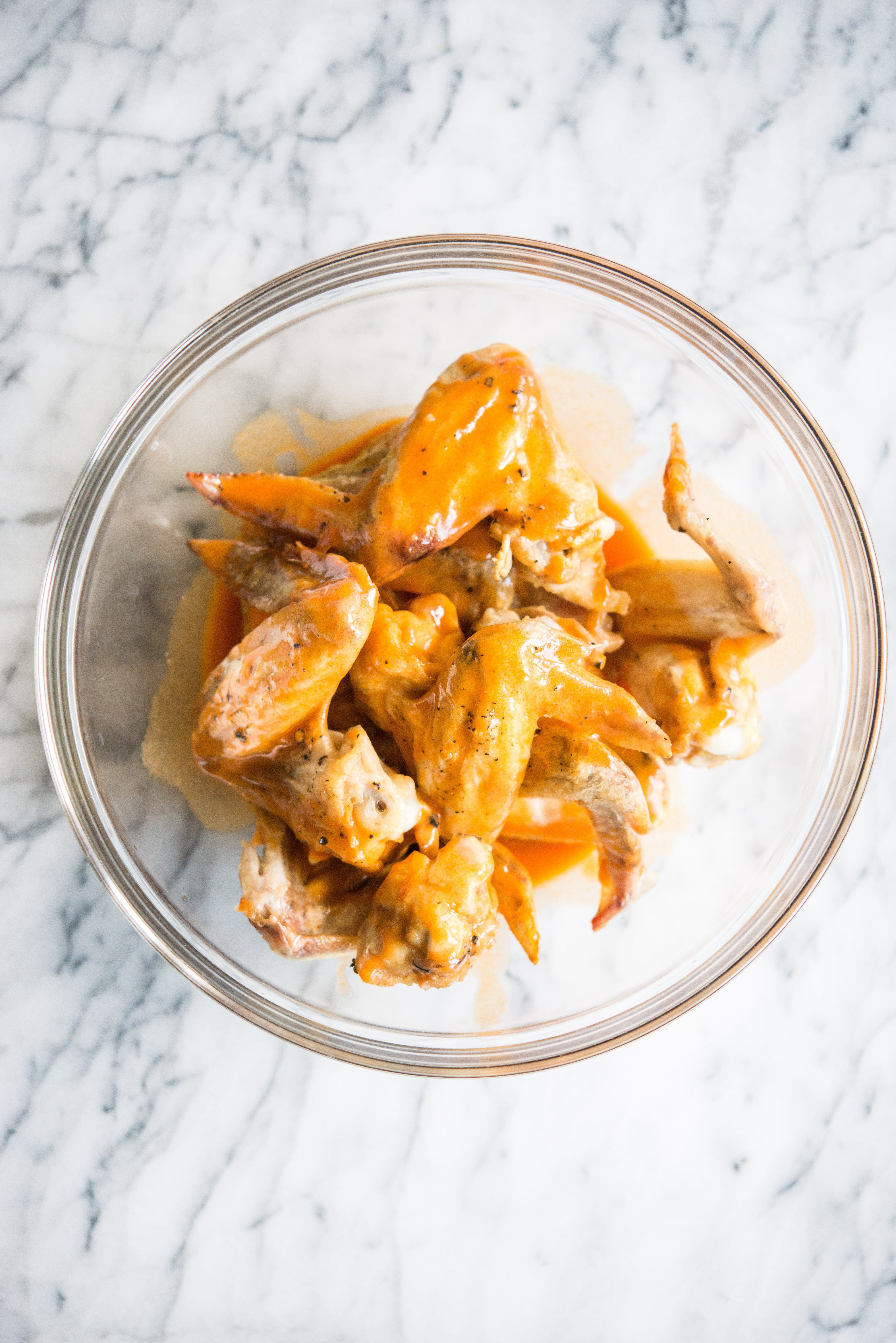 chicken wings in a bowl with buffalo sauce