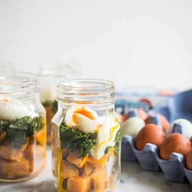 make-ahead balanced breakfast jars - sweet potatoes, kale, and soft boiled eggs in a mason jar on a marble board