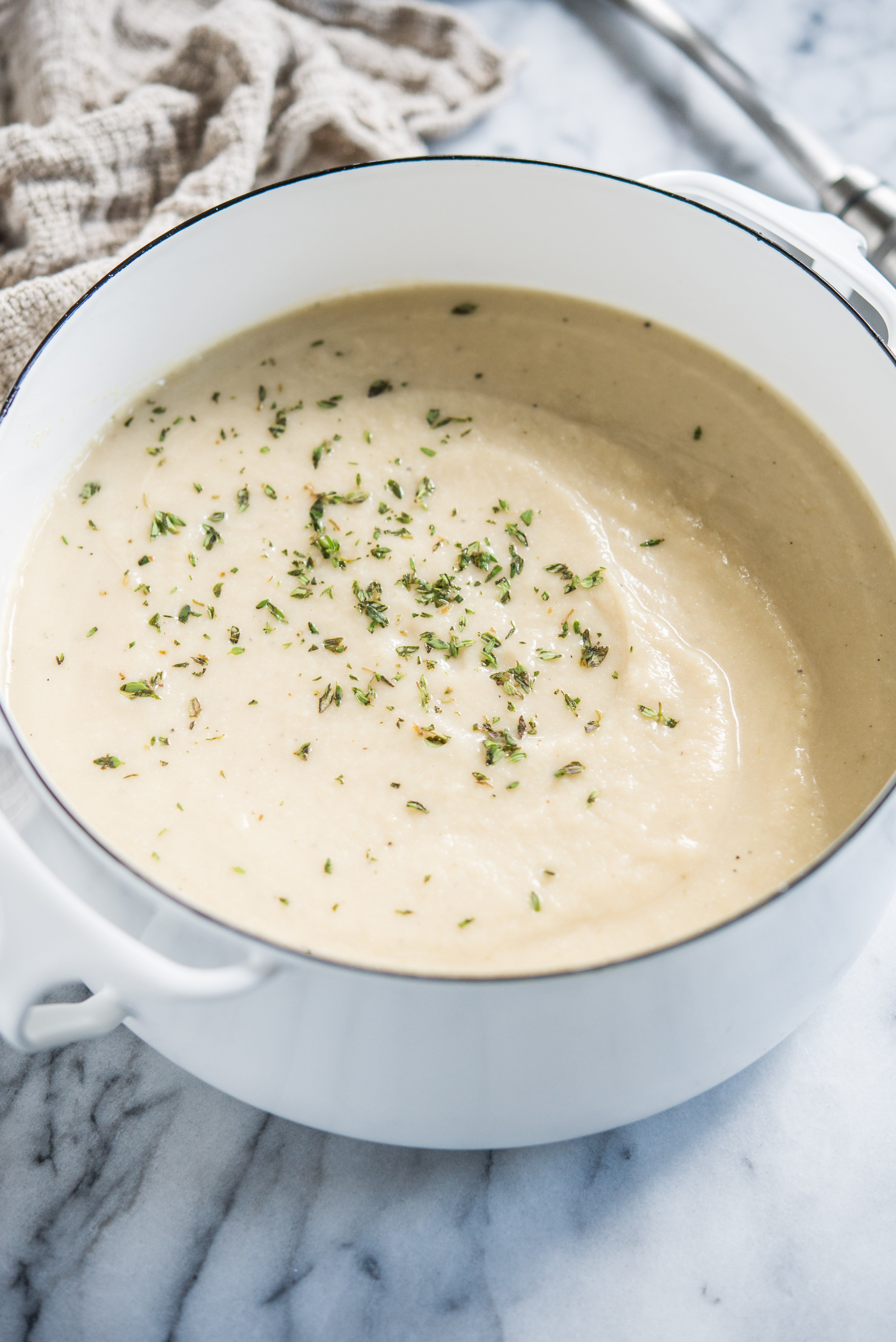 Instant pot cauliflower soup in a white pot on a marble board