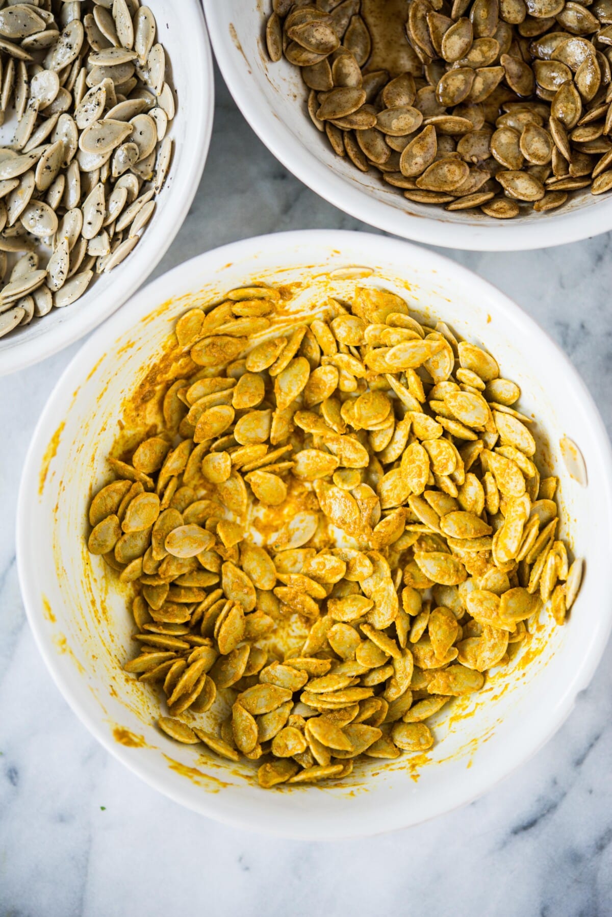 homemade pumpkin seeds tossed in curry seasoning in a white bowl
