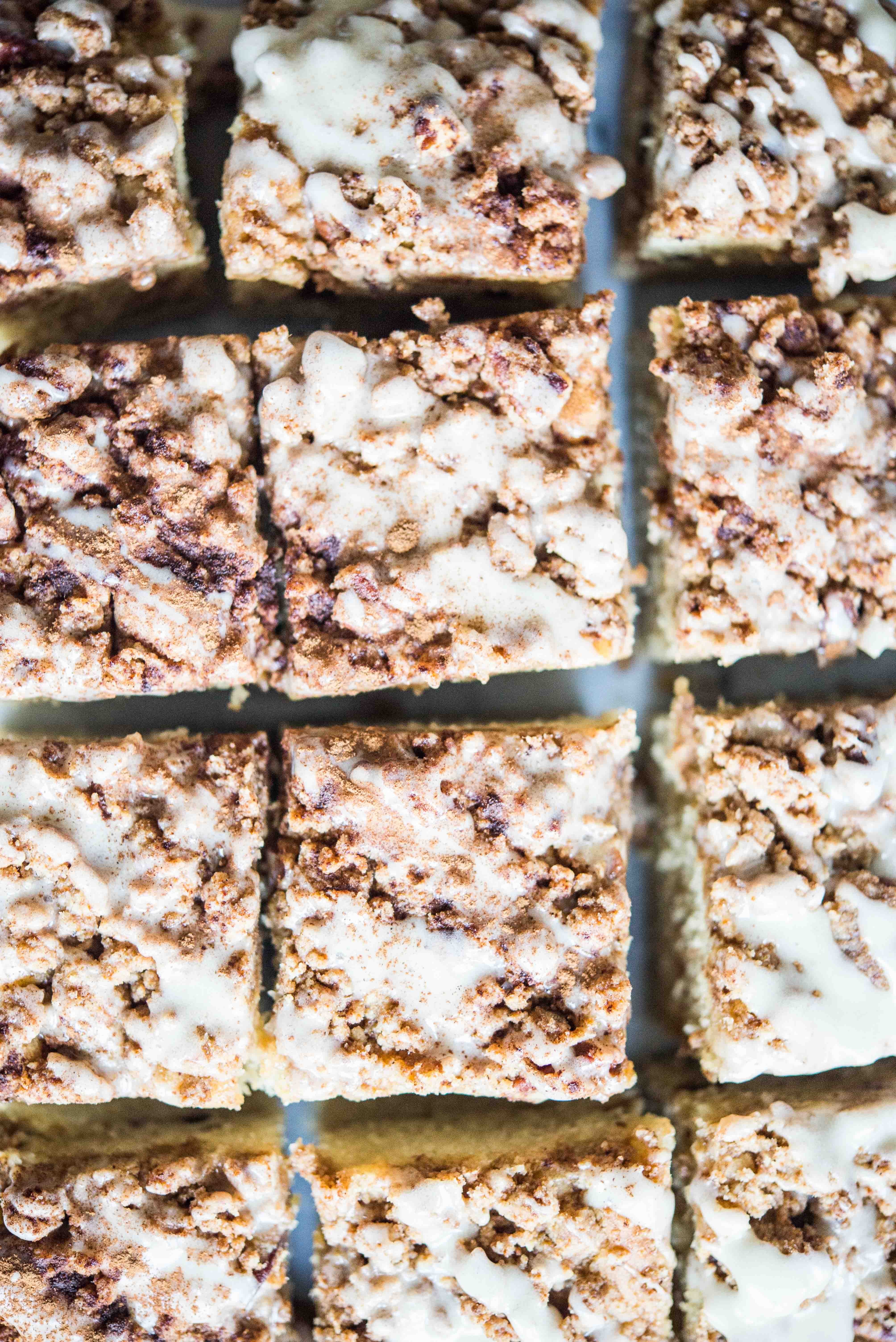  Zimtschnecken-Kaffeekuchen mit Zuckerguss oben in Quadrate geschnitten und auf eine Marmoroberfläche gelegt