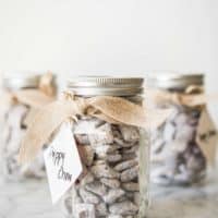 puppy chow in a mason jar with a bow tied around it and a gift tag that says 'puppy chow'