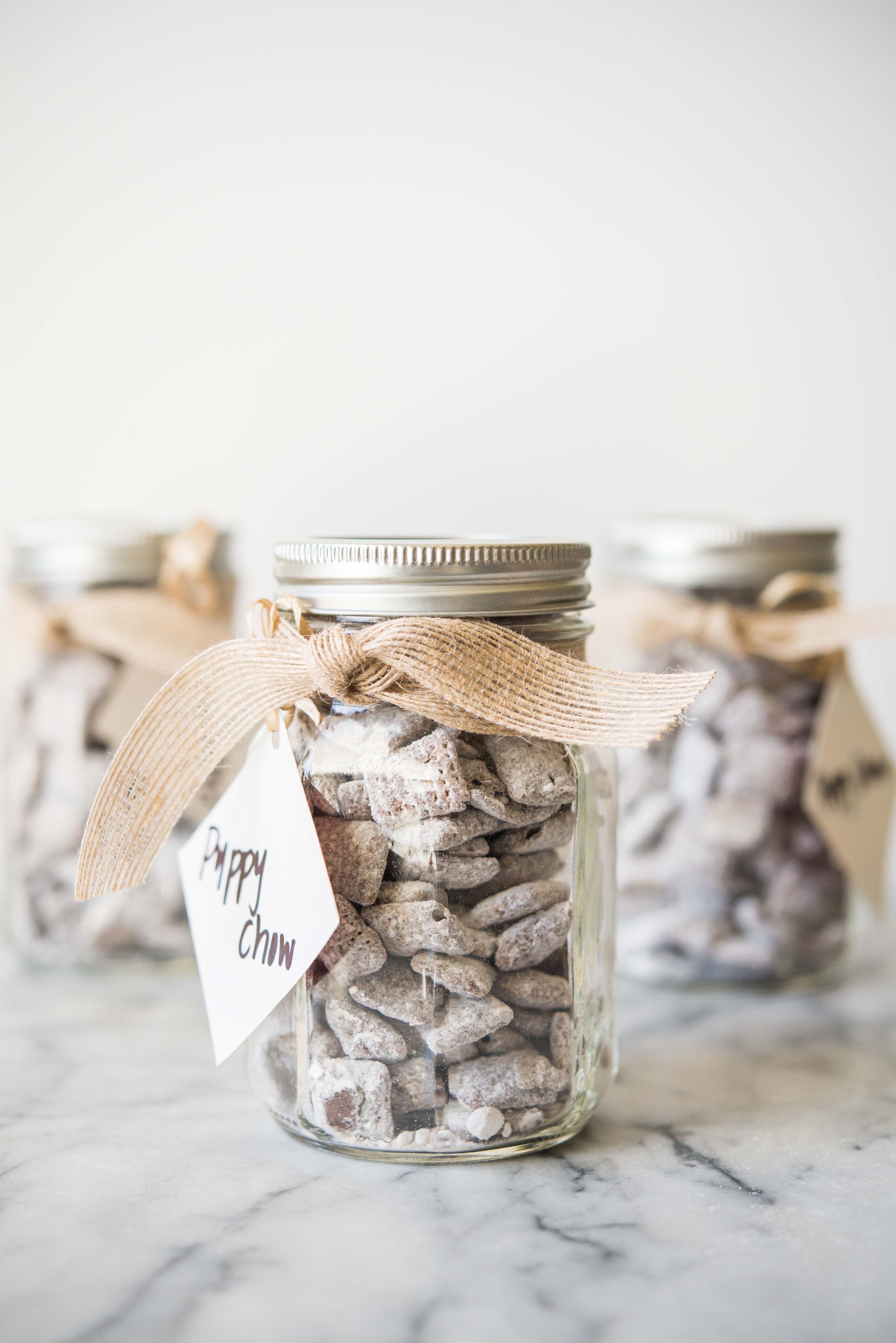 puppy chow in a mason jar with a bow tied around it and a gift tag that says 'puppy chow'