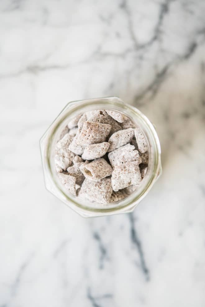 overhead shot of puppy chow in a glass mason jar on a marble surface