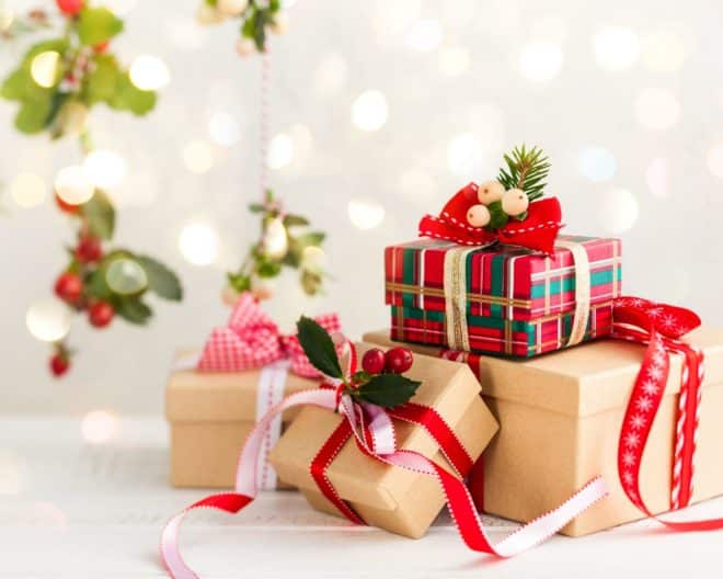 homemade christmas gifts wrapped with lights and holly in the background