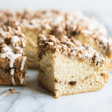 cinnamon roll coffee cake with a swirl of cinnamon sugar in the middle on a marble surface