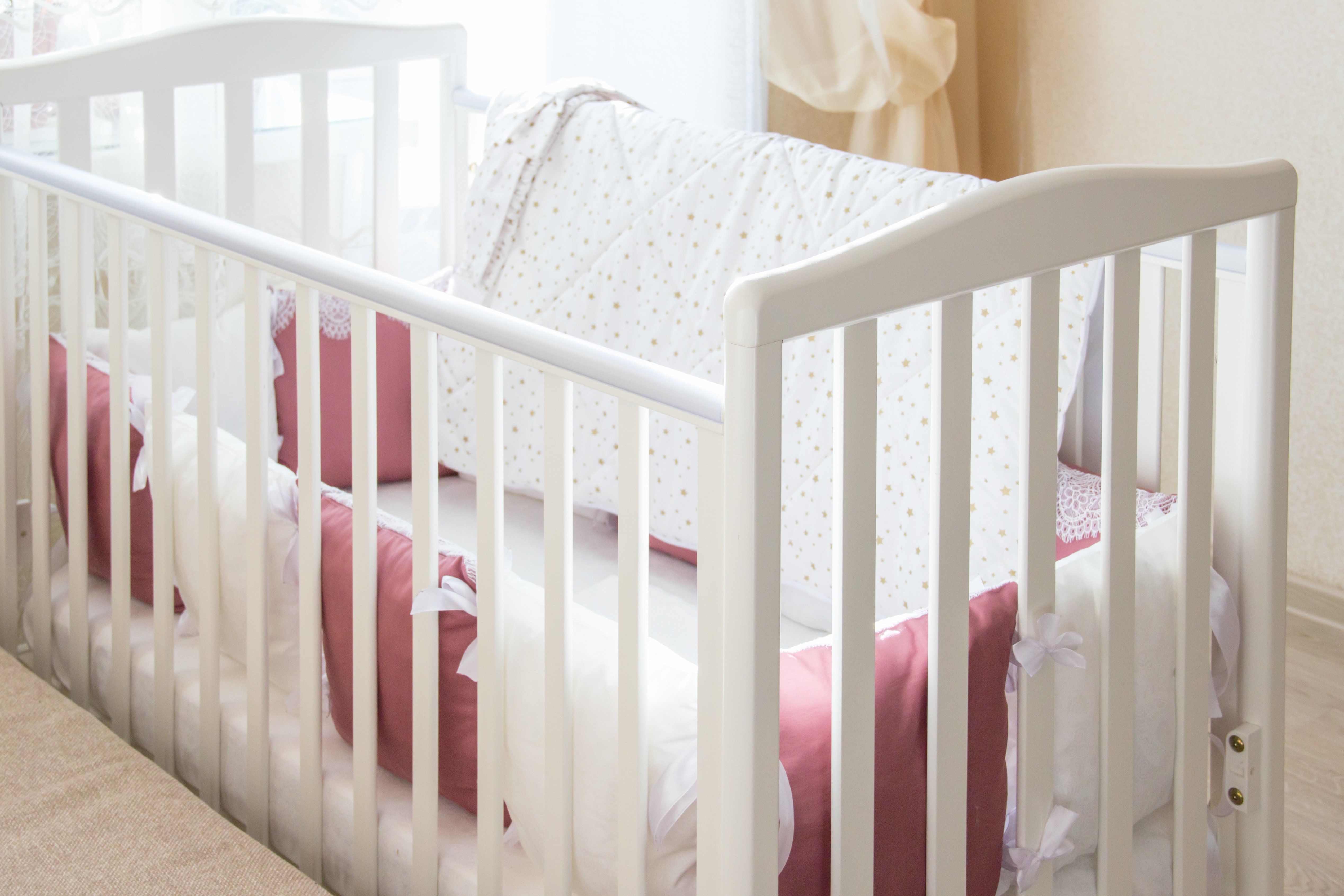 white crib with pink pillows - sleep training methods