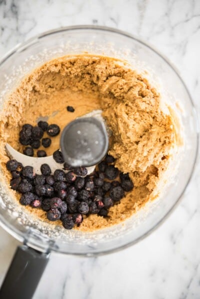 energy ball batter in a food processor with dried blueberries mixed in