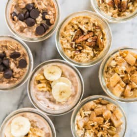 mason jars filled with 4 types of overnight oats on a marble surface