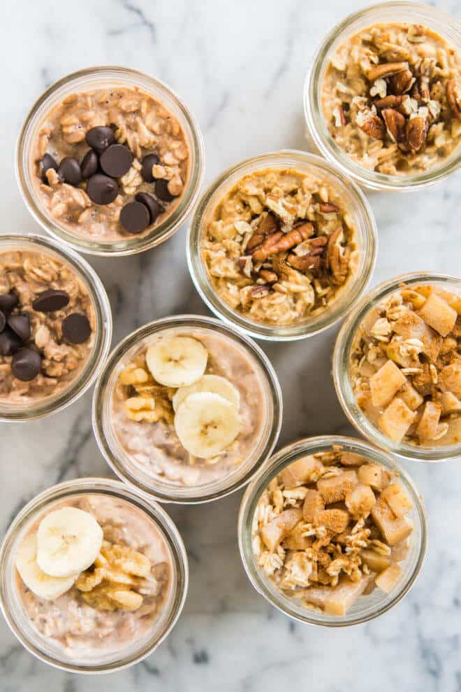 mason jars filled with 4 types of overnight oats on a marble surface