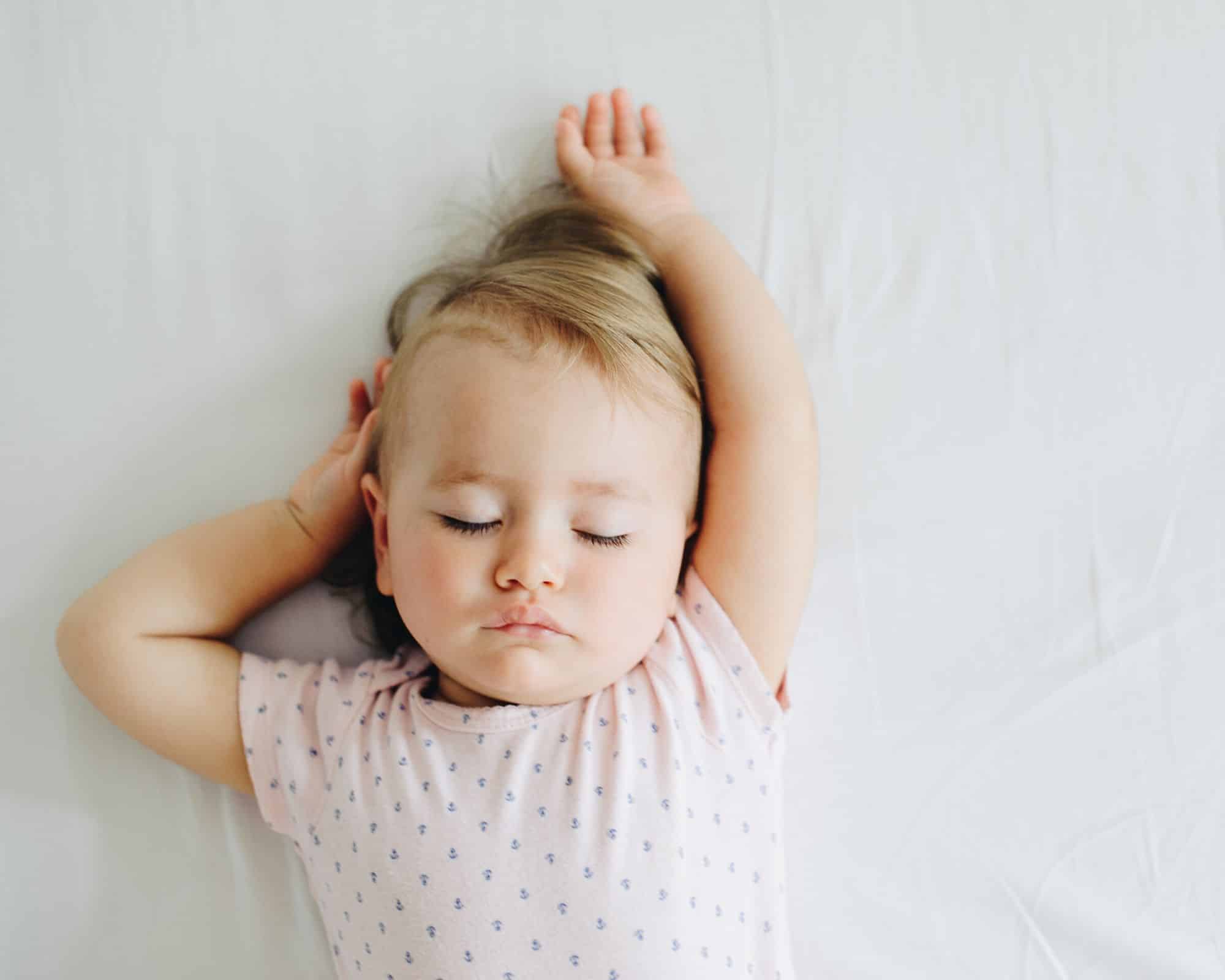 baby sleep - little girl asleep on a white sheet