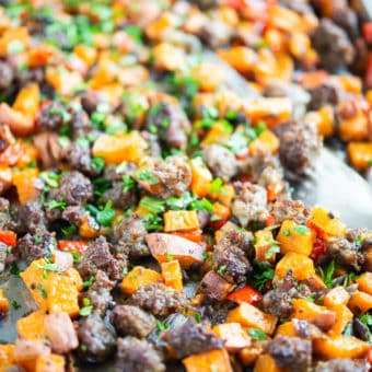sweet potato hash on a sheet pan - crumbled sausage, bell pepper, and sweet potato breakfast hash on a sheet pan on a marble surface