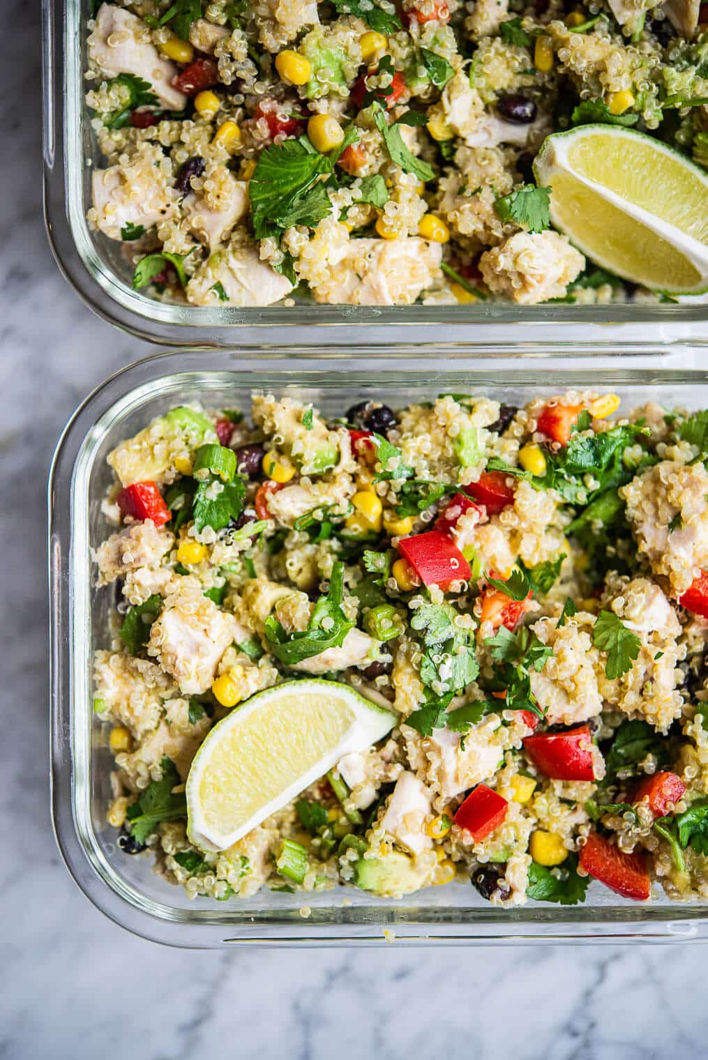 two rectangular glass containers filled with southwestern quinoa salad side by side on a marble surface