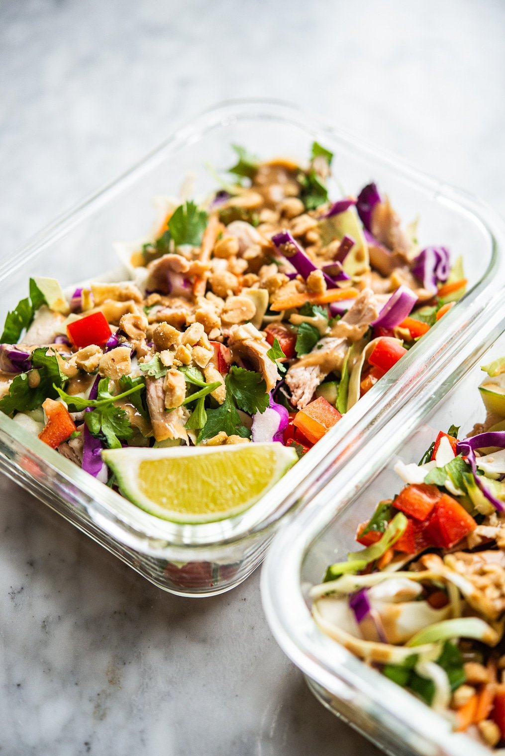 colorful thai chopped chicken salad in 2 individual serving glass meal prep containers