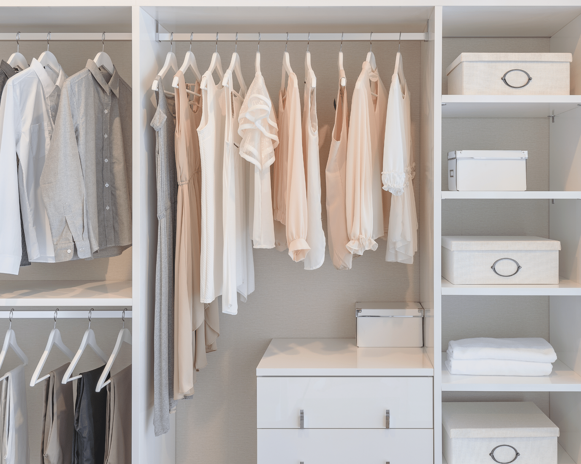 organized closet with white and pink shirts, a dresser, and white boxes