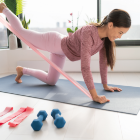 woman on a yoga mat working out with resistance bands