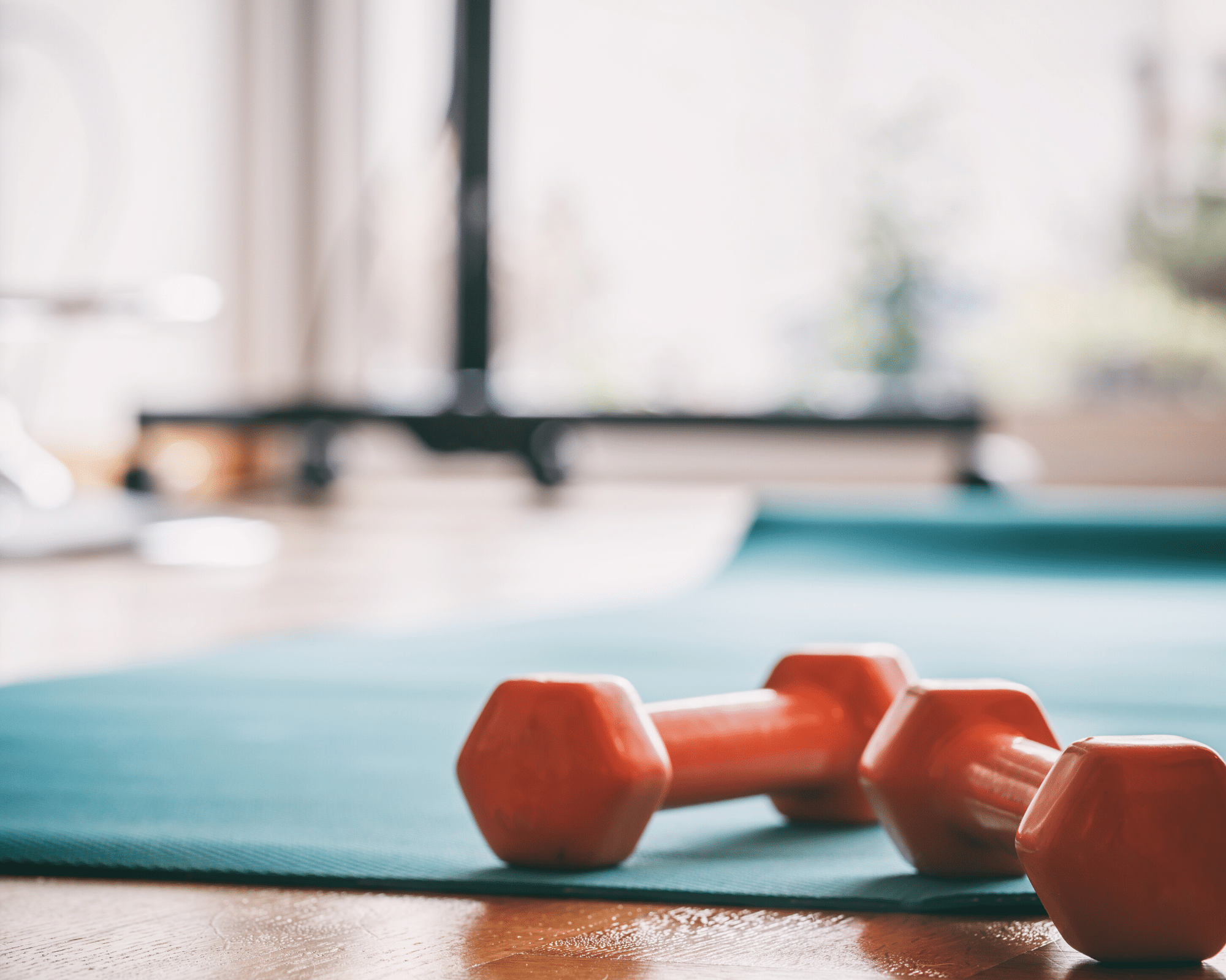 two dumbbells on a blue workout mat