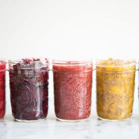 side view of 5 mason jars with different colored chia jam