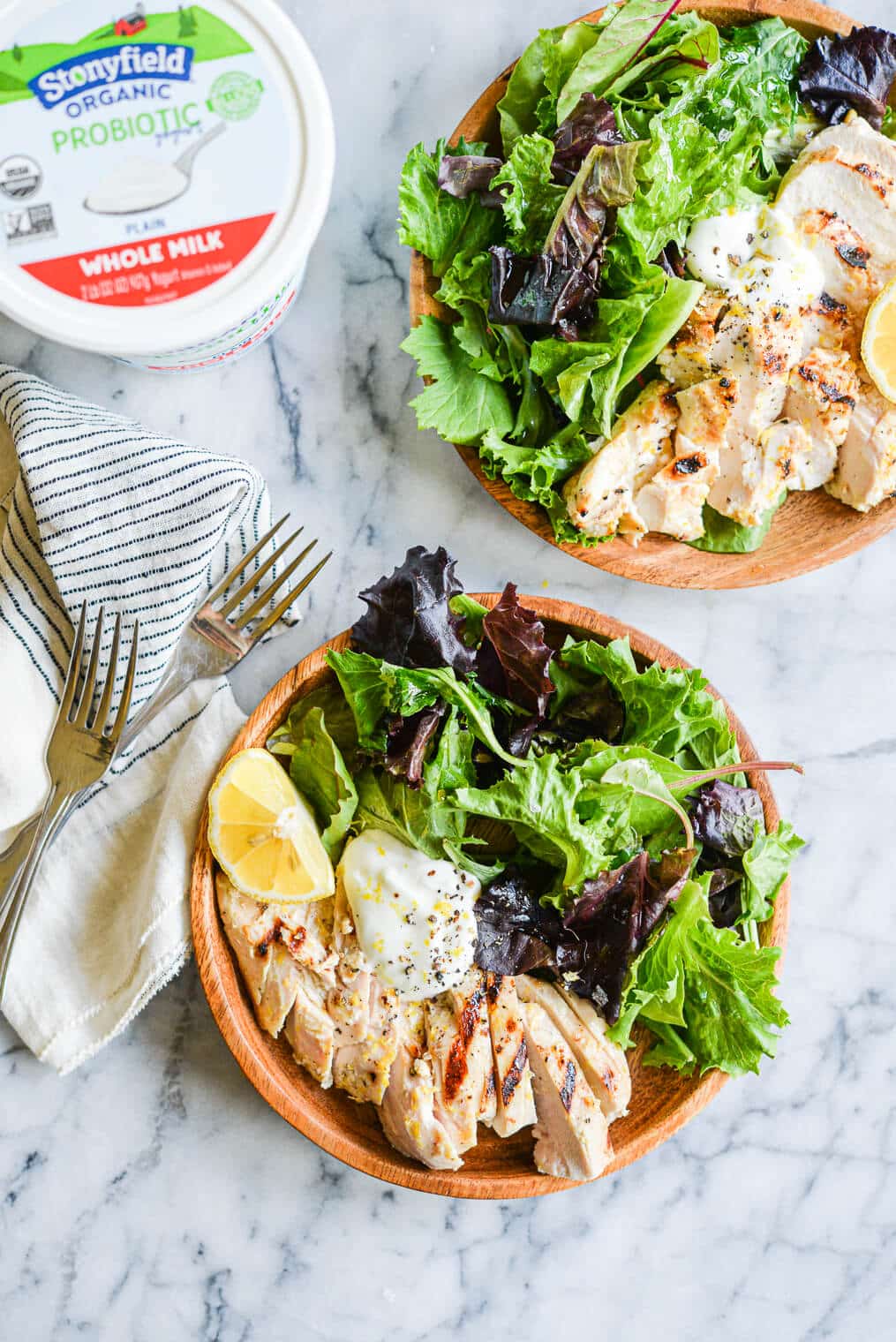 lemon pepper yogurt grilled chicken sliced and served in a bowl on top of mixed greens