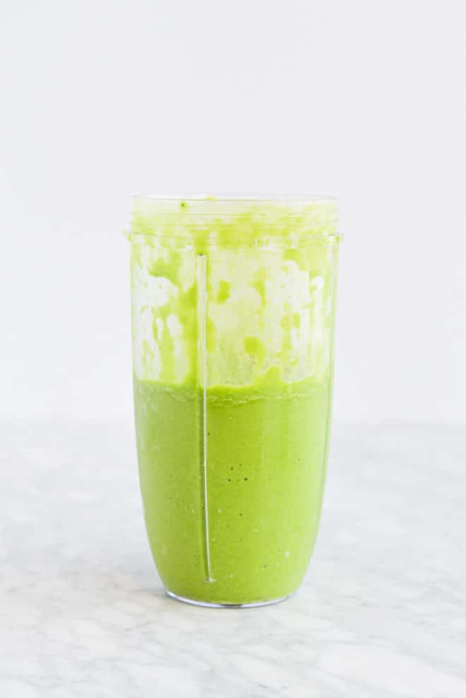 a blended, ready to drink low carb green smoothie in an individual serving blender cup on a marble surface