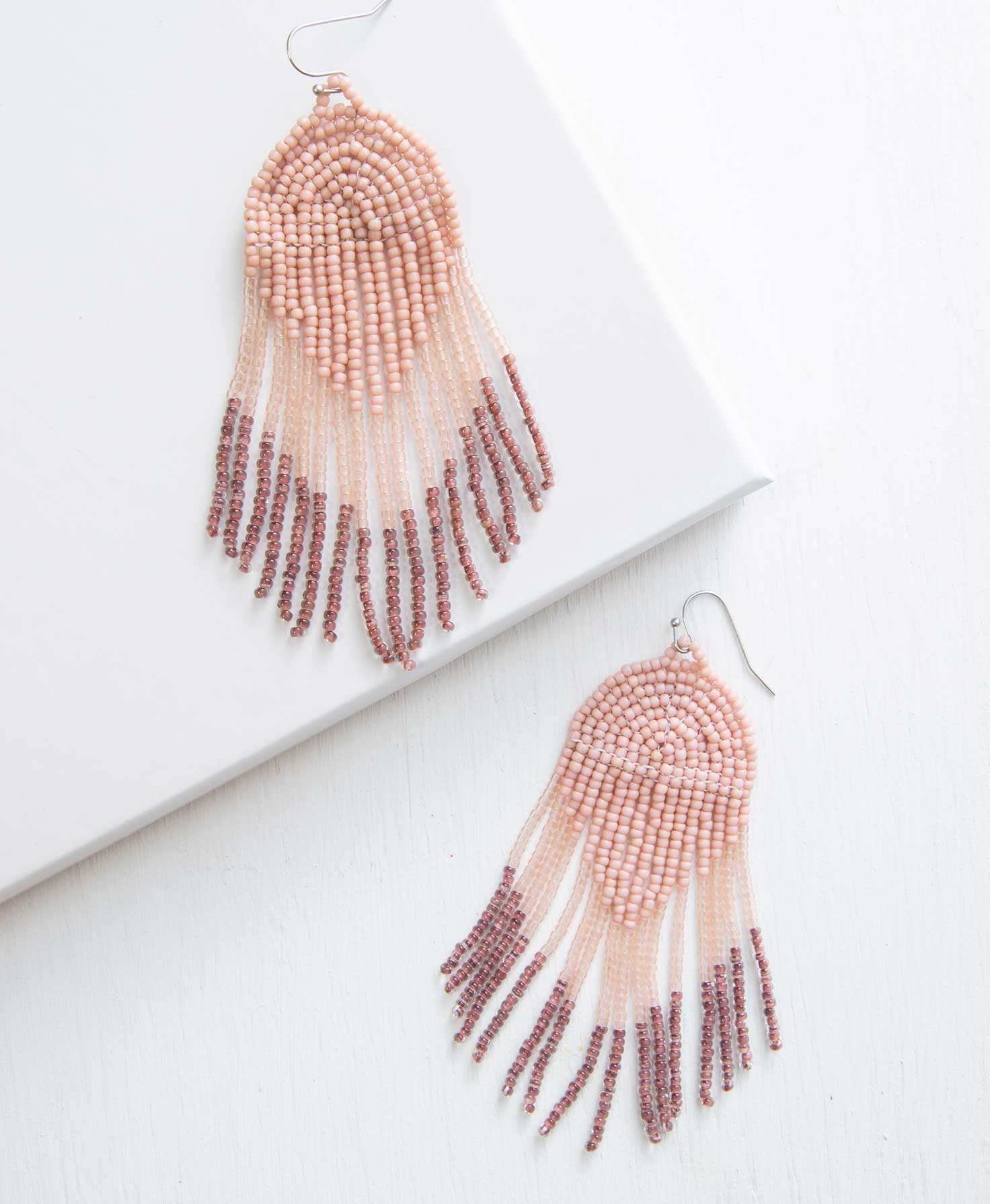 beaded pink earrings on a white surface