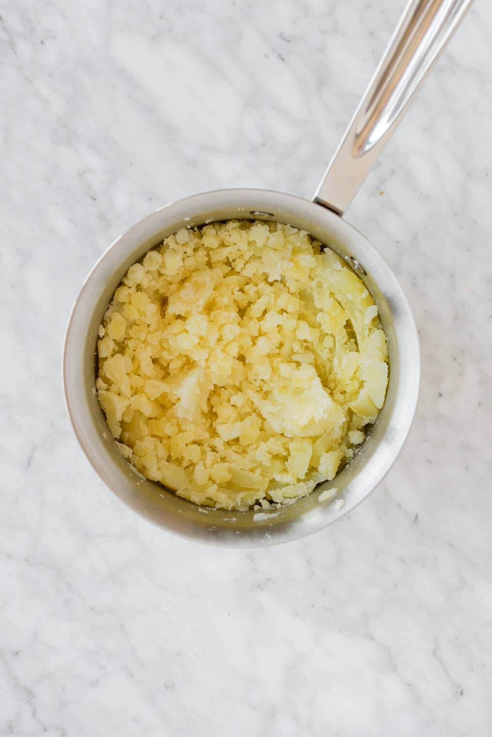 just mashed potatoes sitting in a pot on a marble surface