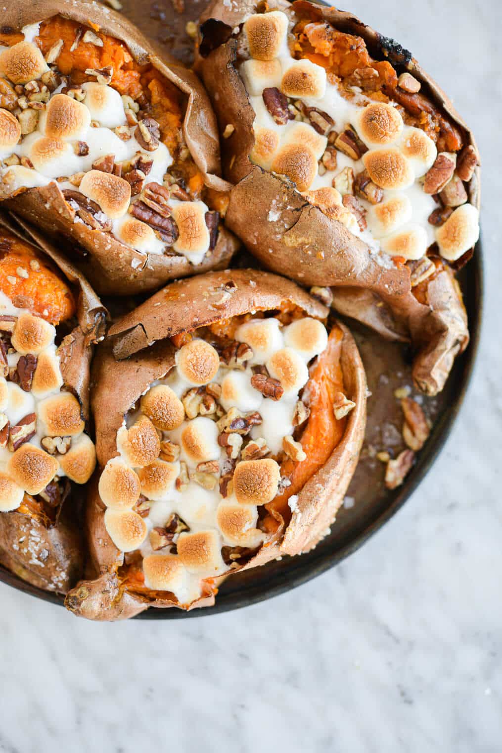 top view of marshmallow and pecan topped baked sweet potatoes