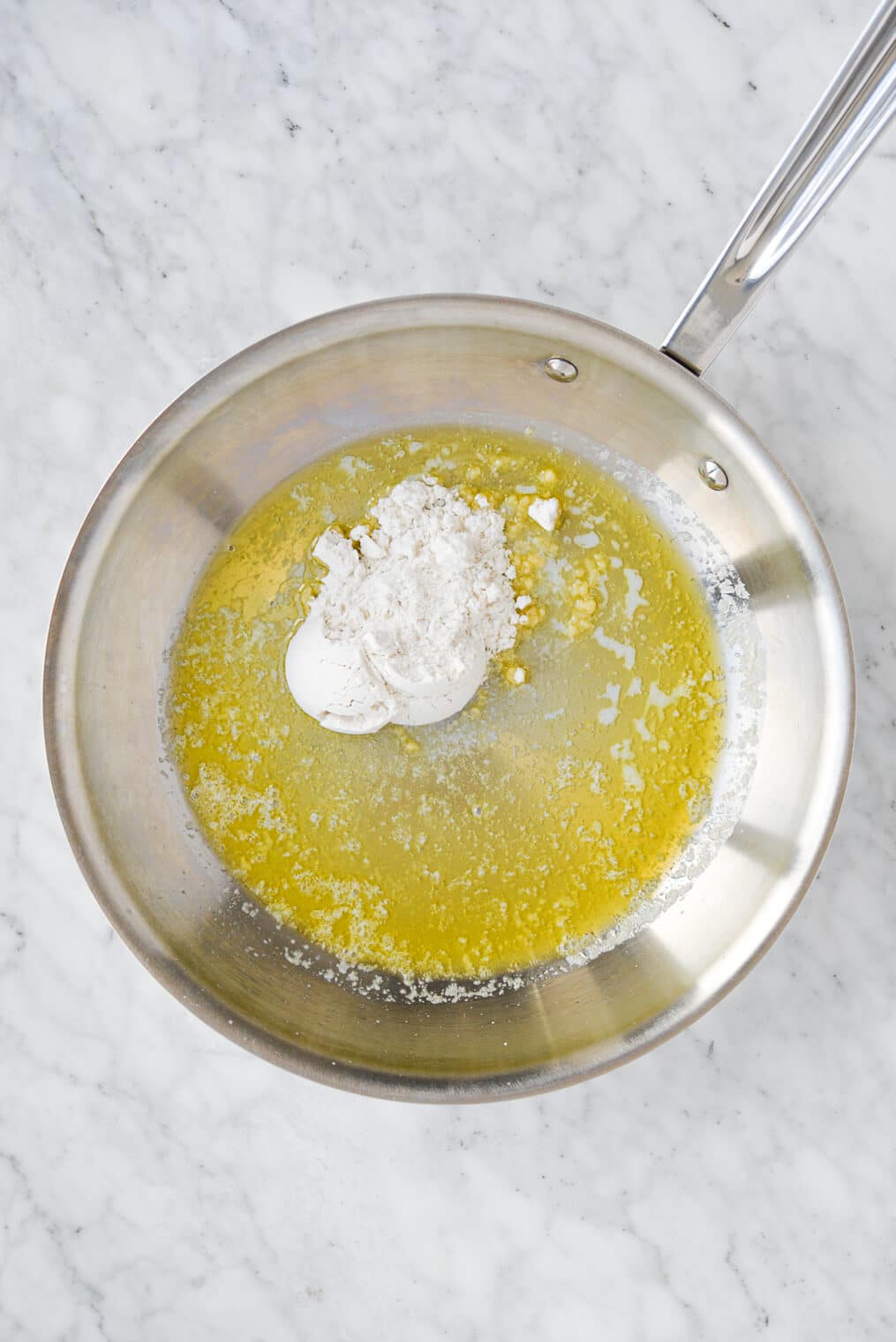 top view of a stainless steel pan with melted butter and flour