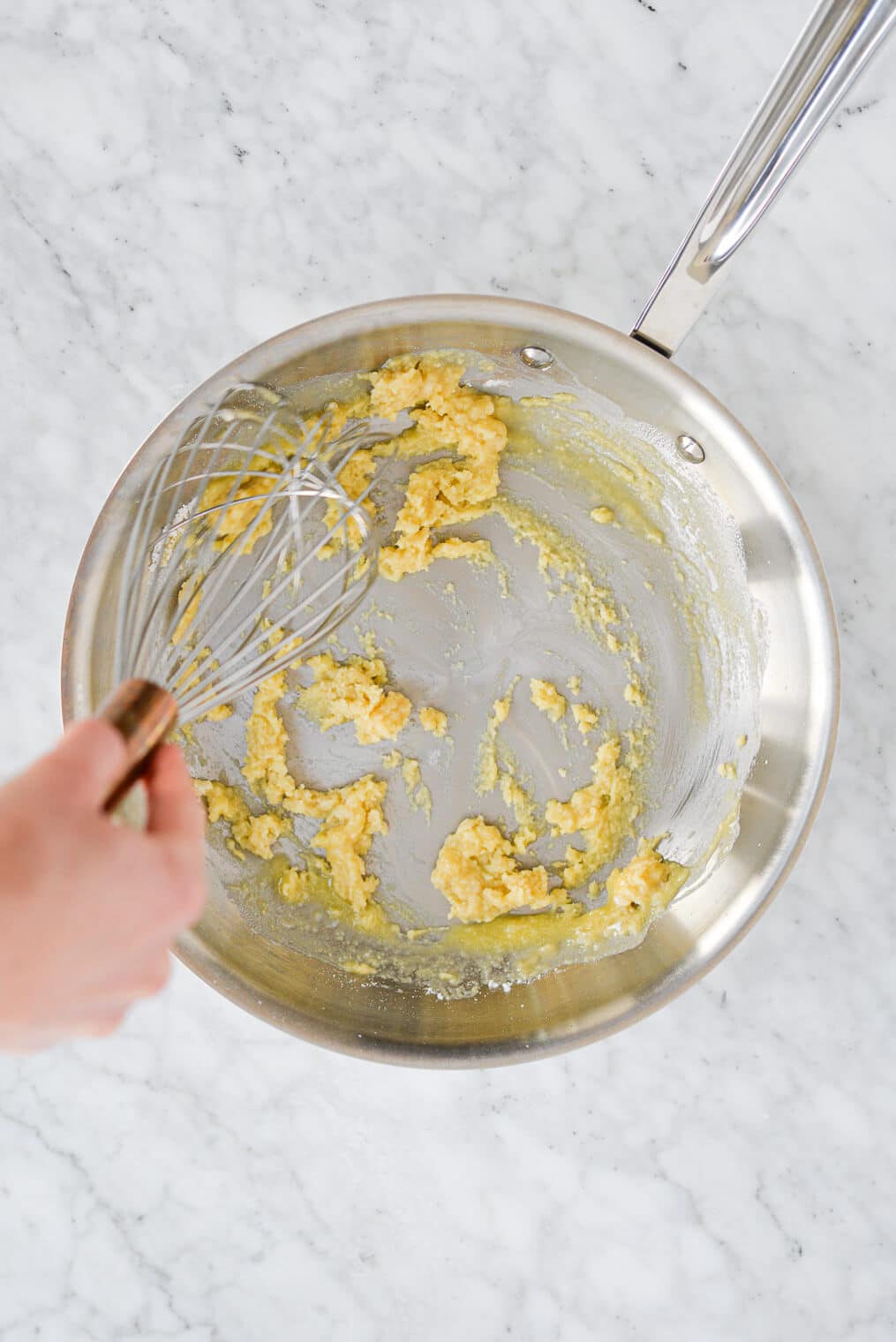 top view of someone whisking flour into melted butter to start a classic gravy