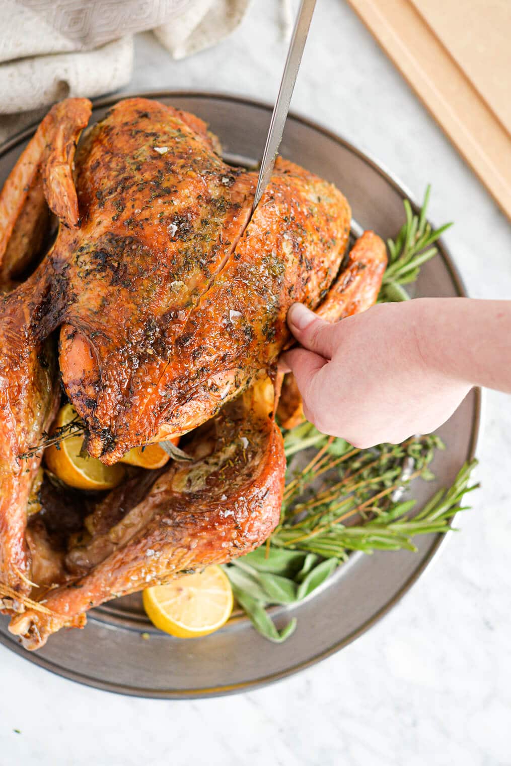 top view of a whole roasted turkey being carved