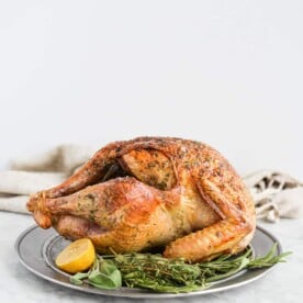 side view of a whole roasted turkey sitting on a platter