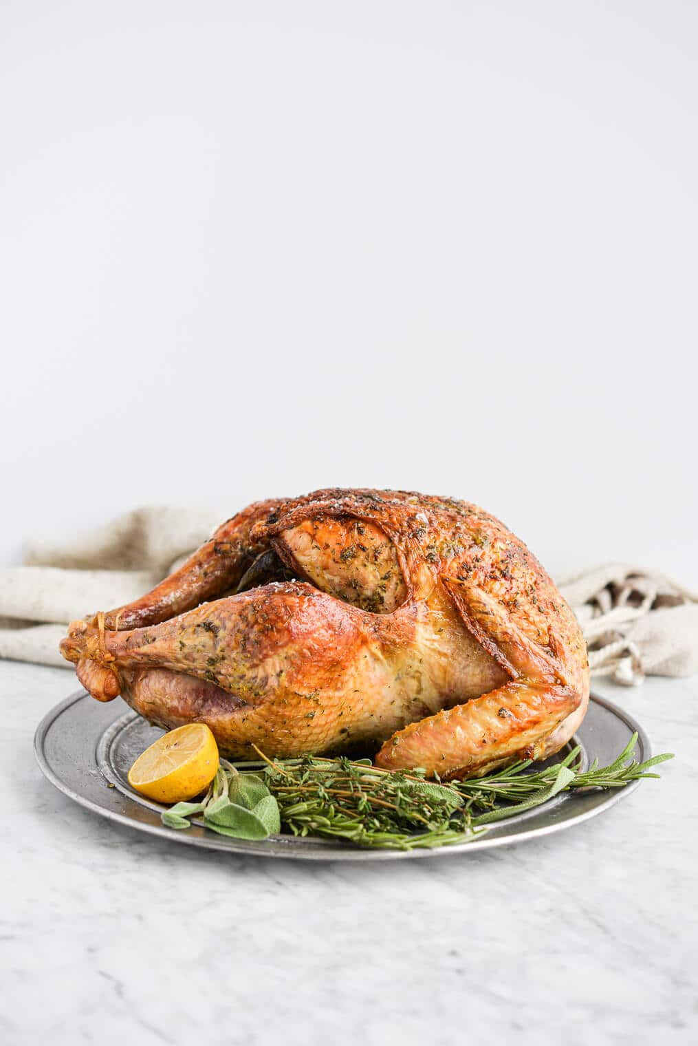 side view of a whole roasted turkey sitting on a platter