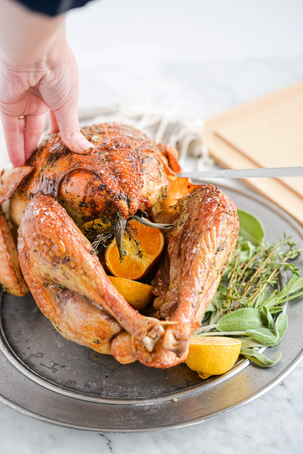 a whole roasted turkey being carved with a large knife