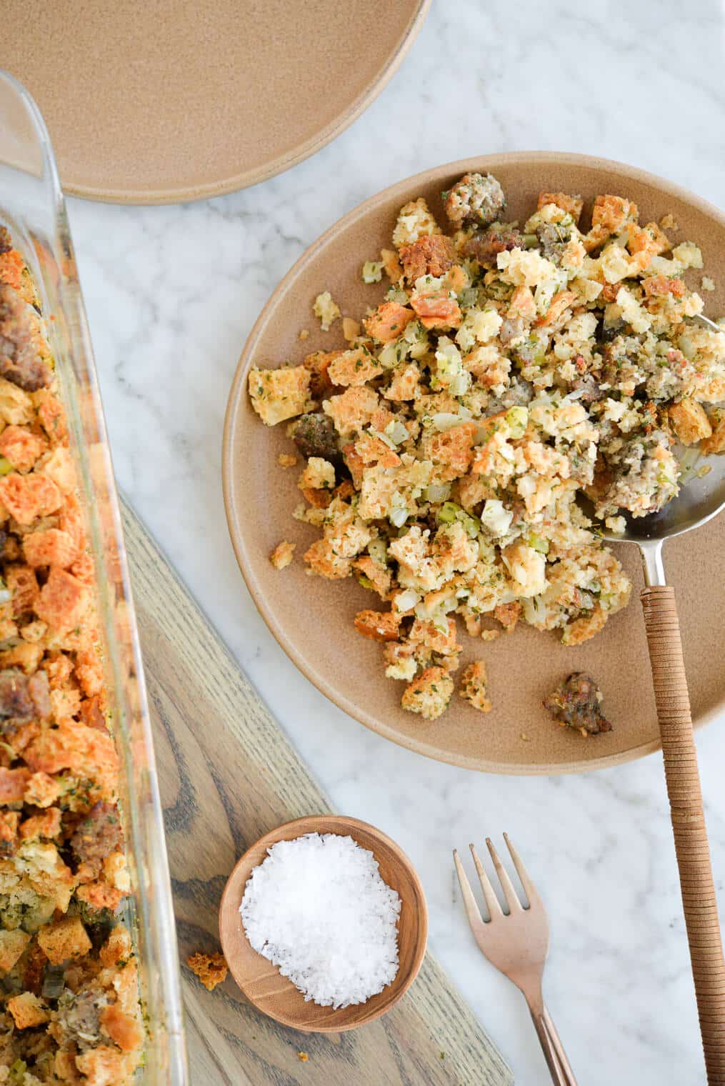 top view of a plate of semi-homemade stuffing sitting next to a casserole dish of semi-homemade stuffing