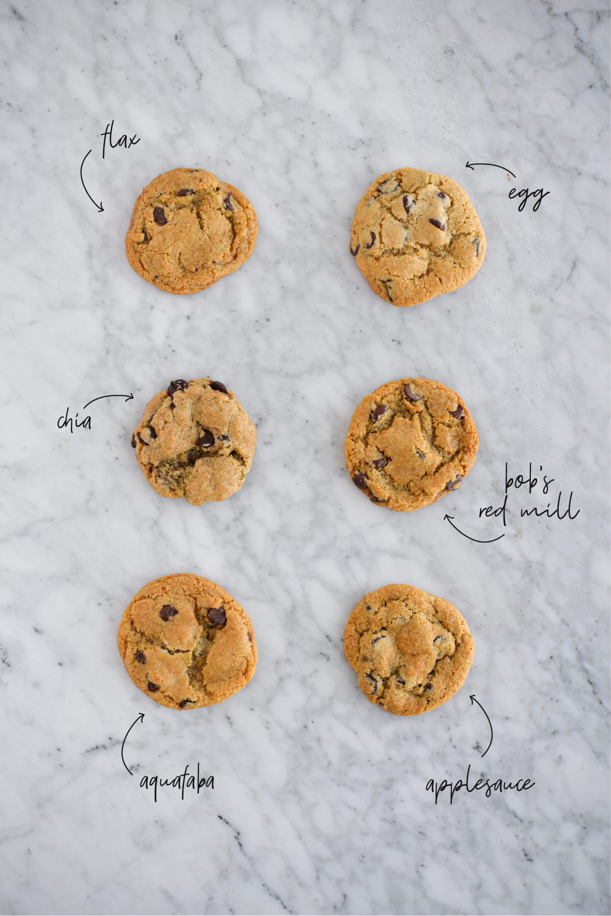 6 cookies lined up in 2 rows on a marble surface to compare different egg substitutes