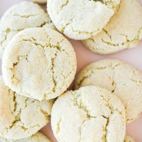 a close up of chewy cream cheese sugar cookies laying on a light pink plate