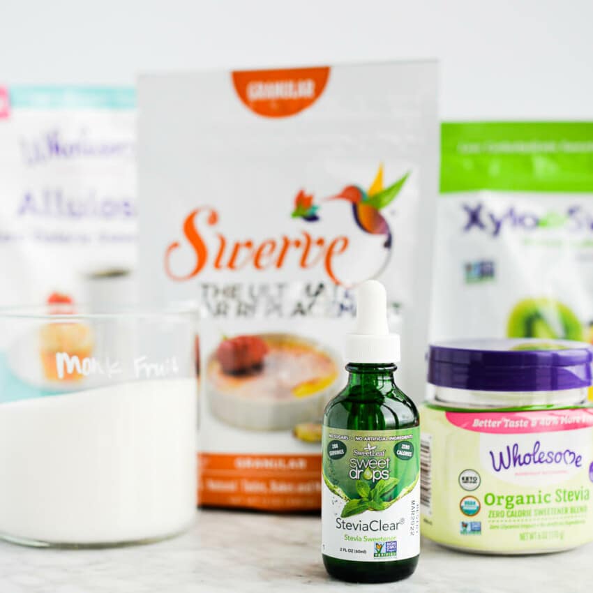 6 sugar substitutes (allulose, swerve, xylitol, stevia, and monk fruit) laying on a marble surface