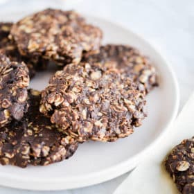 a plate of finished no bake oatmeal cookies sitting on a marble surface
