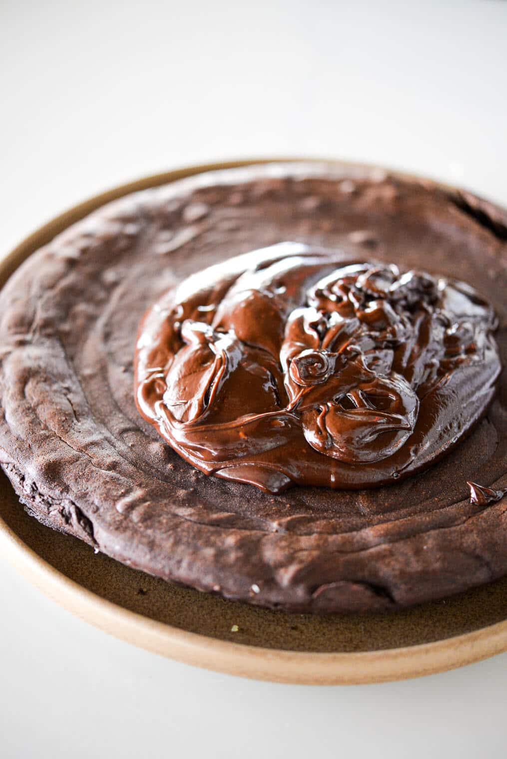 a whole flourless dark chocolate cake with hard cider ganache dolloped in the middle of it