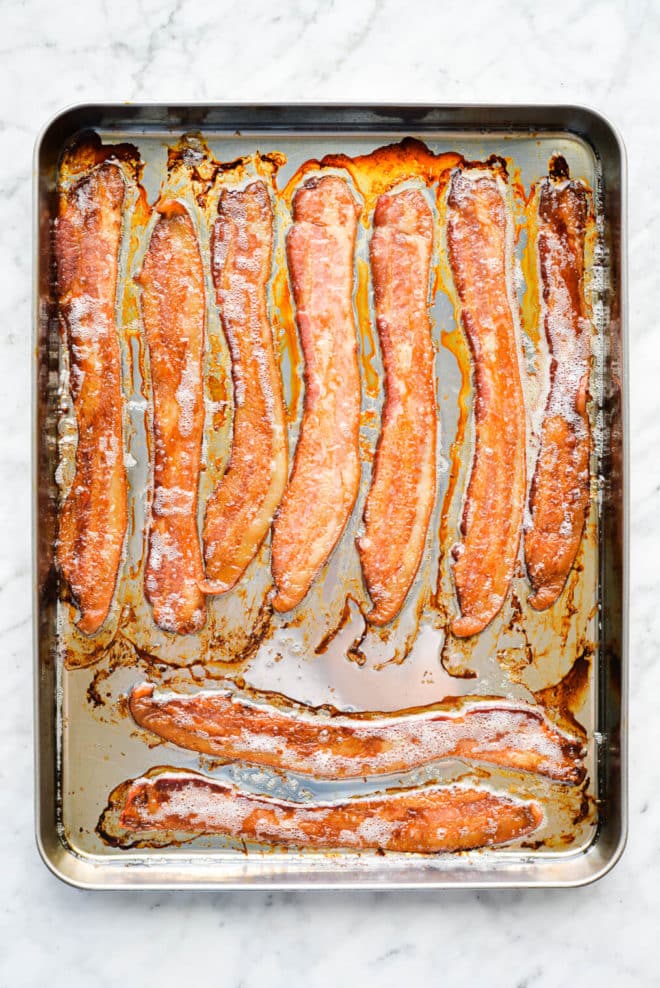 9 slices of cooked bacon laying on a sheet pan