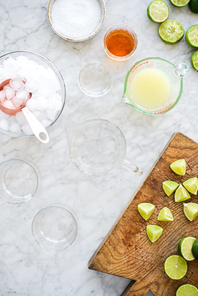 all of the ingredients for a classic margarita sitting on a marble surface
