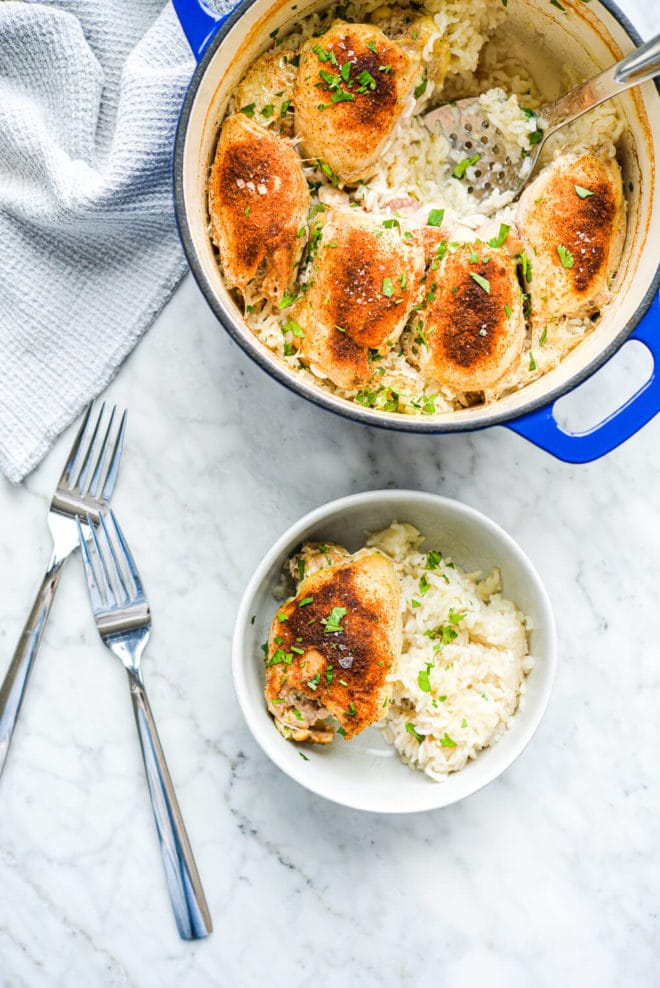 a serving of chicken and rice bake sitting next to a large pot of chicken and rice bake