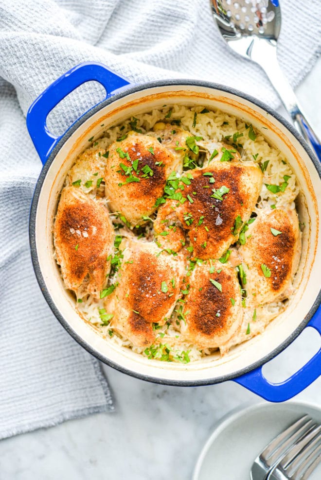 a finished enameled cast iron pot of cooked chicken and rice bake