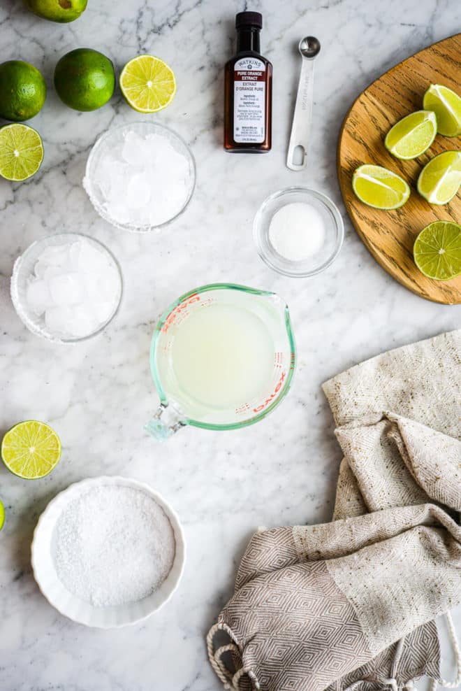 all of the ingredients for a keto margarita sitting on a marble surface