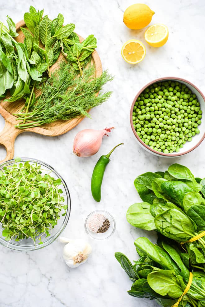 all of the ingredients for a spring salad sitting on a marble surface